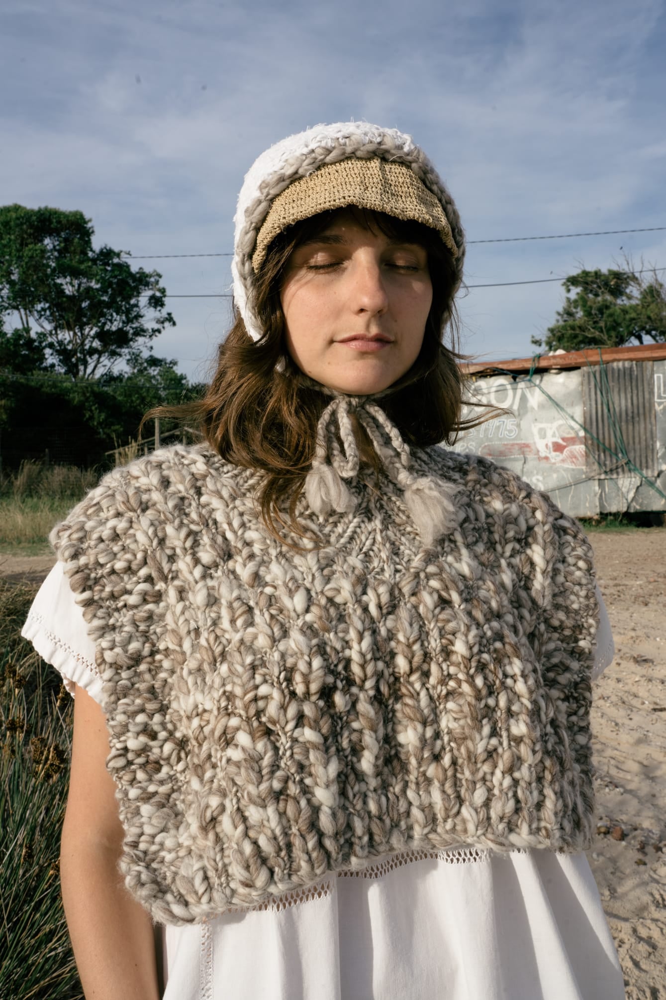 Vest Higo full view — hand-knitted merino wool, styled on figure.