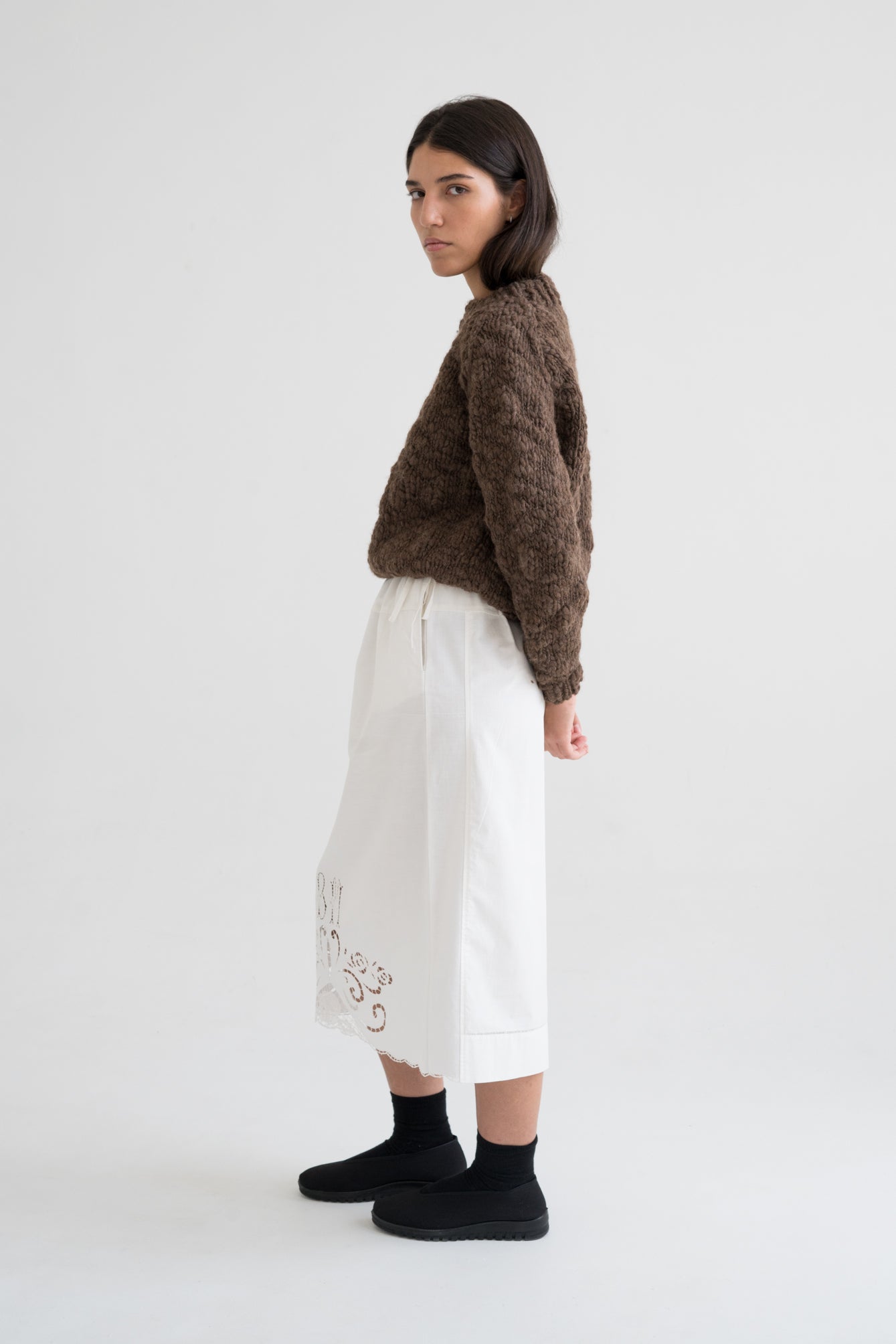 Model wearing Caven Jumper in earth brown — relaxed slow-fashion styling.
