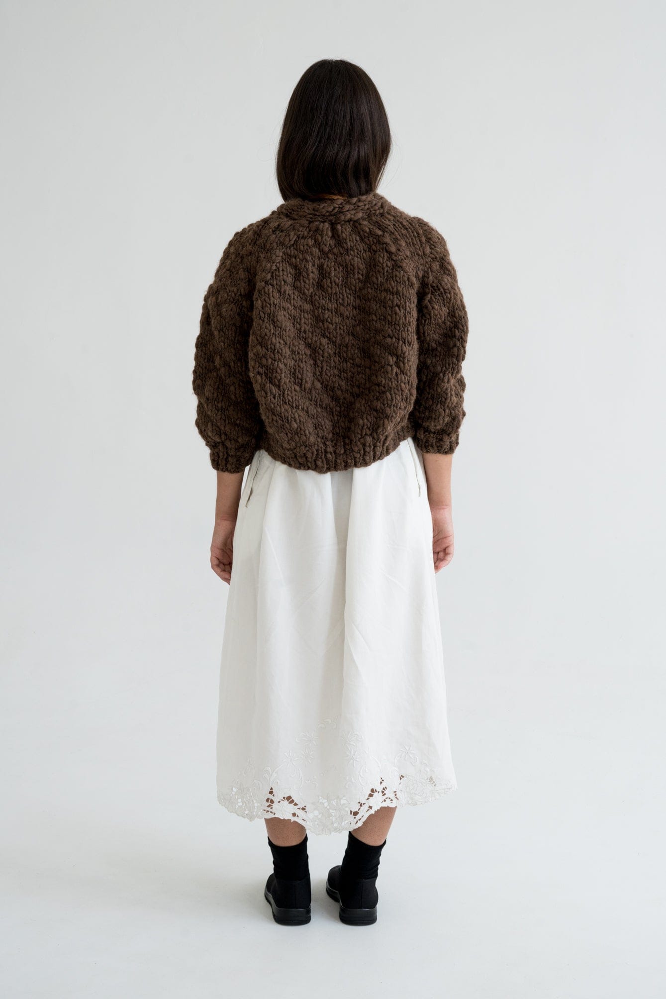 Model wearing Jacaranda Cardigan in earth brown — relaxed slow-fashion styling.