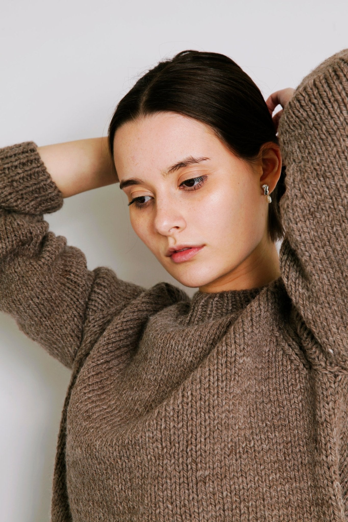 Model wearing Molle Jumper in warm brown — relaxed slow-fashion styling.