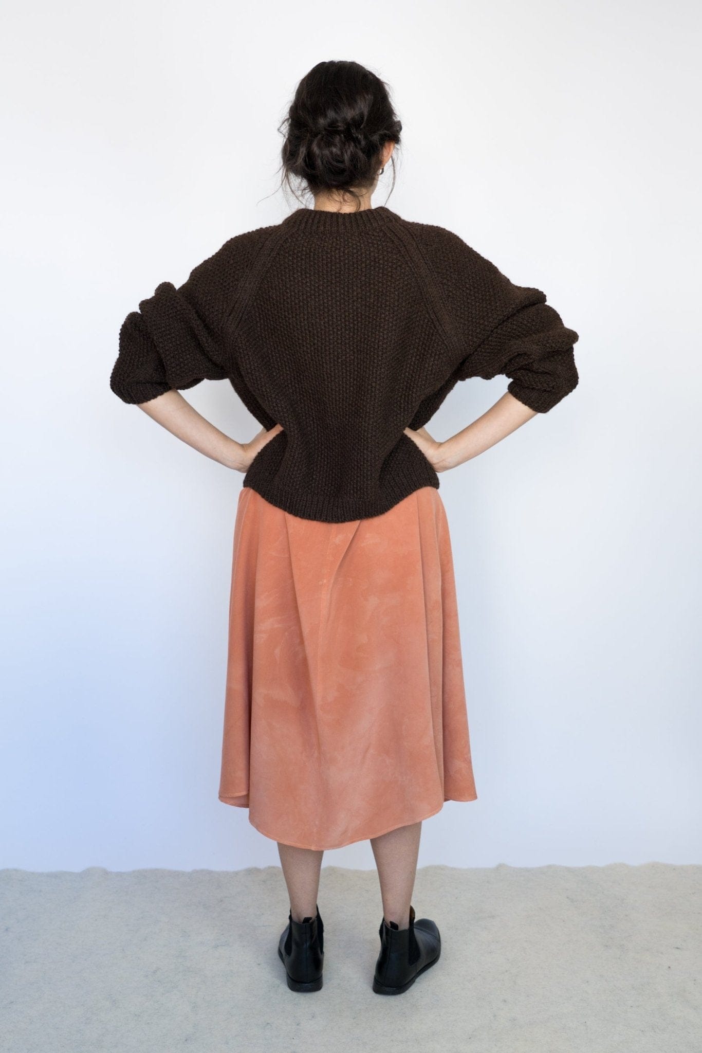 Model wearing Naca Jumper in earth brown — relaxed slow-fashion styling.