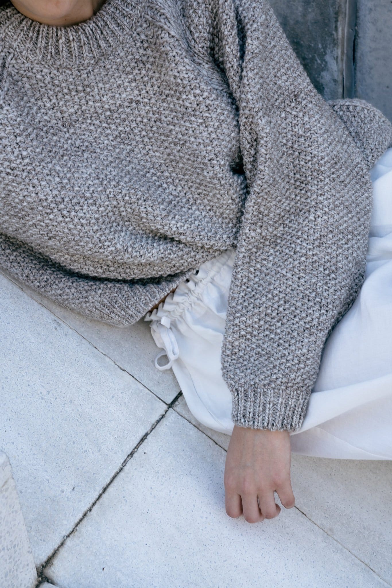 Model wearing Naca Jumper in soft stone grey — relaxed slow-fashion styling.