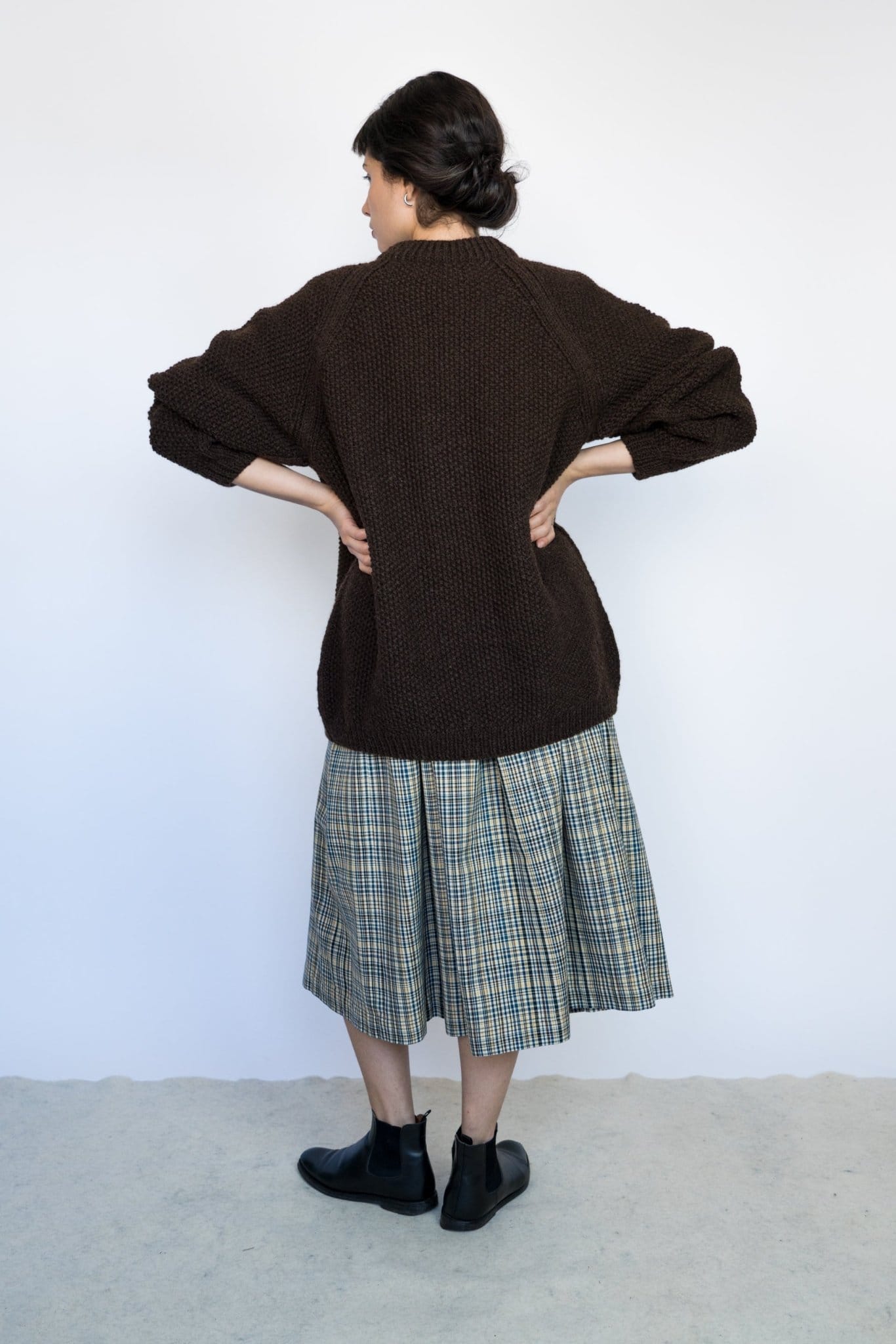 Model wearing Roble Jumper in earth brown — relaxed slow-fashion styling.