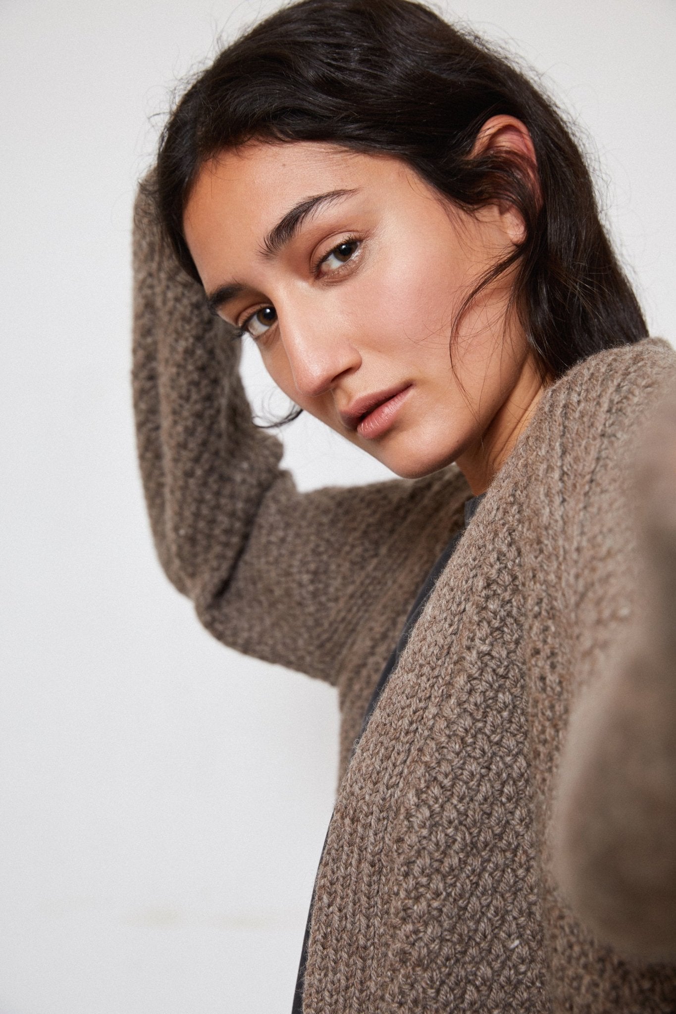 Model wearing Sauco Cardigan in warm brown — relaxed slow-fashion styling.