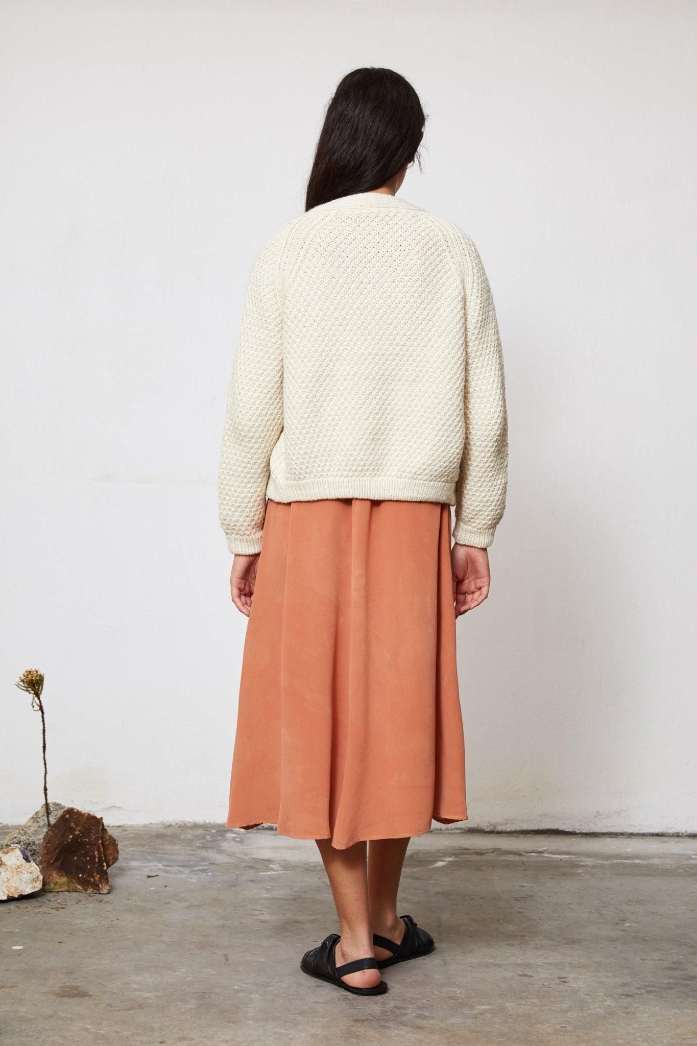 Model wearing Sauco Cardigan in soft ivory — relaxed slow-fashion styling.